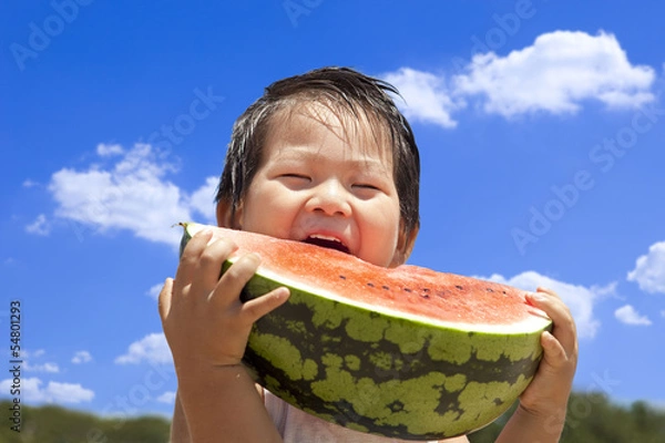 Fototapeta 青空の下でスイカを食べる子供