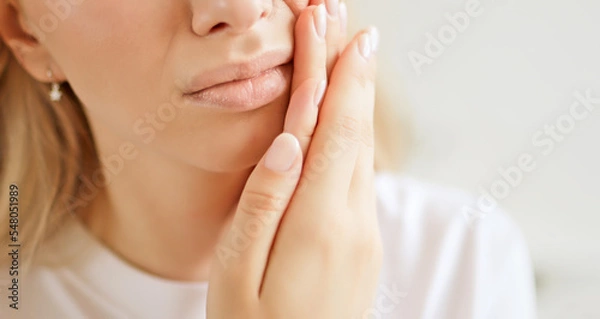 Obraz Woman with a toothache, touching her face. The concept of dental disease. Tooth pain due to caries