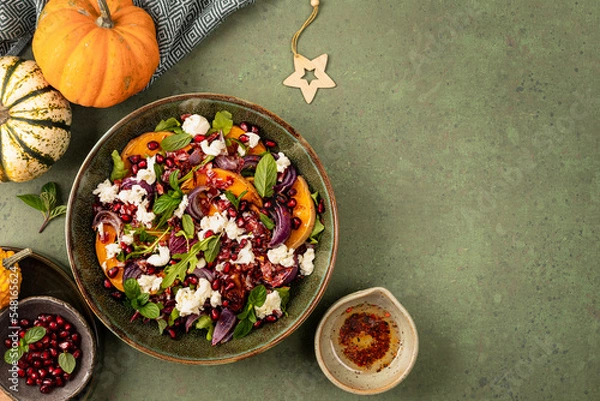 Fototapeta Warm winter quinoa salad with pumpkin, chorizo and mozzarella, arugula leaves and pomegranate.
