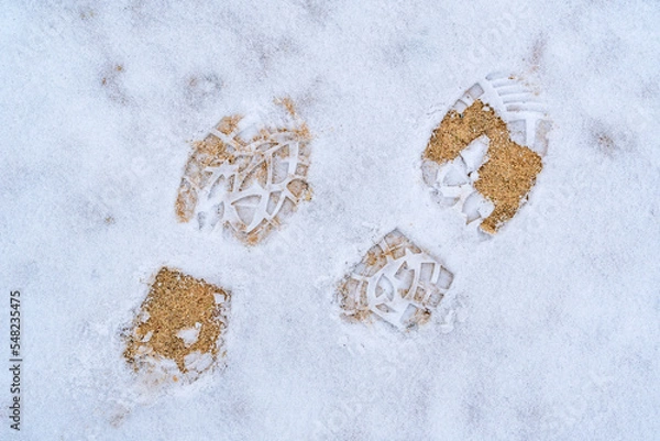 Fototapeta Footsteps on snow ground on the first snowy day