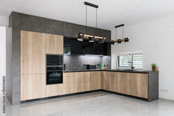 Fototapeta Combination of black and wood in modern kitchen with built in appliances