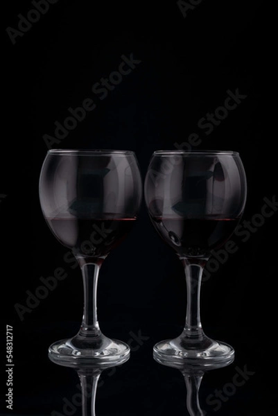 Fototapeta glasses of red wine on a black background with reflection