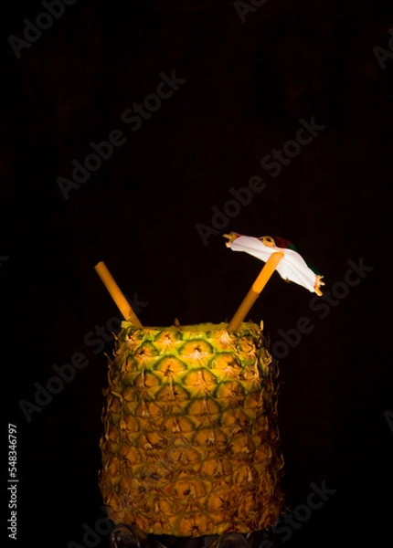 Fototapeta Exotic pineapple in the shape of a drink, with organic straw and mini umbrella
