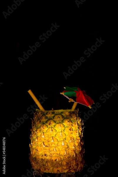 Fototapeta Exotic pineapple in the shape of a drink, with organic straw and mini umbrella
