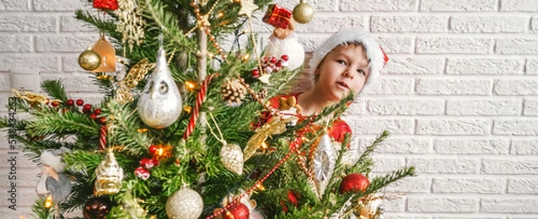 Fototapeta Little child with decorated Christmas tree, copy space.