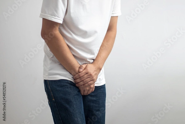 Obraz The man touched the crotch of his pants with pain.