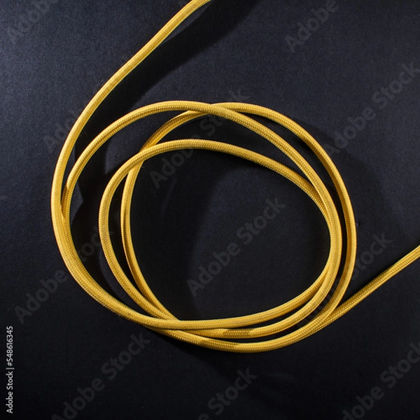 Obraz Yellow Braided Cable on Black Background