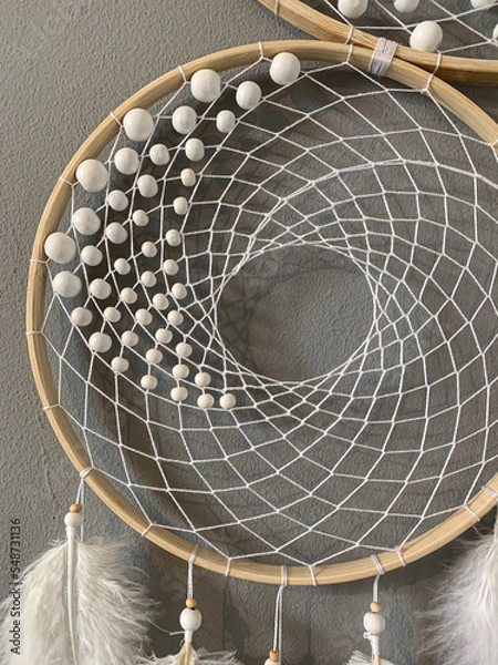 Fototapeta Close-up white feathers dreamcatcher craft on gray background