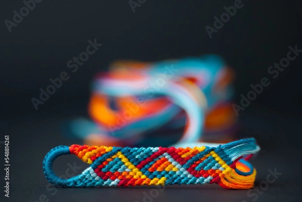 Fototapeta Friendship bracelet in the process of being made - with a beautiful blurry background