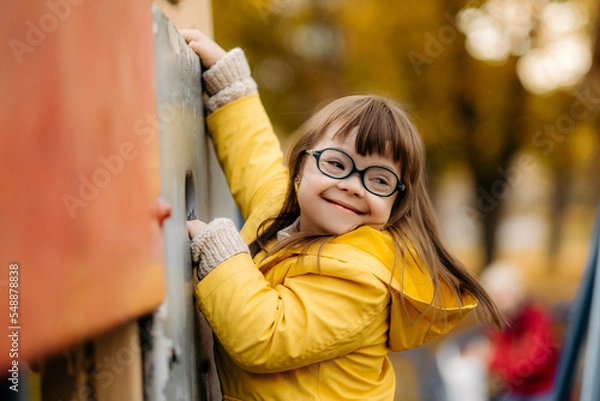 Fototapeta Happy child with down syndrome enjoying swing on playground