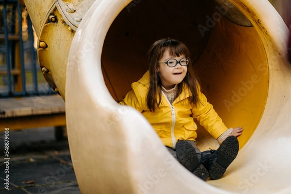 Fototapeta Happy child with down syndrome enjoying swing on playground