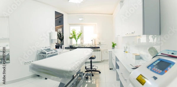 Fototapeta White and comfortable SPA bed standing in the middle of professional, clean and hygienic room for facial and body treatments. Wide copy space shot. High quality photo