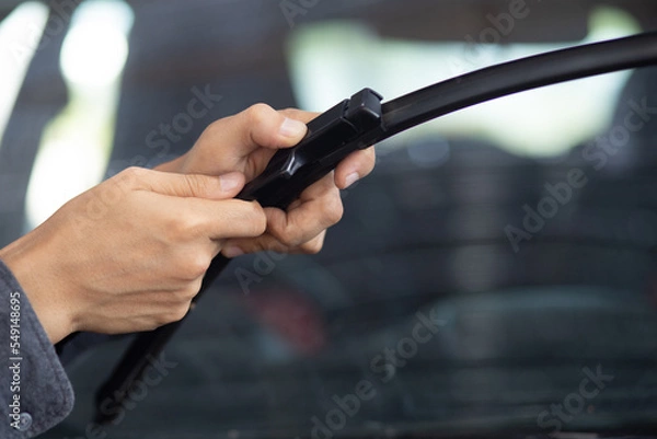 Fototapeta Technician replacing windshield wipers change car wiper blades