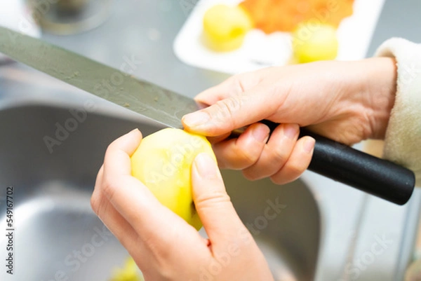 Obraz 皮をむいた後のじゃがいもの芽を包丁で取り除いている写真