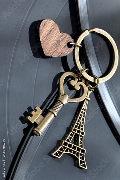 Fototapeta key with a keychain in the shape of a heart and an eiffel tower on a black background