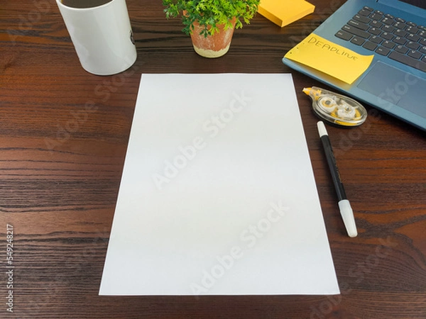 Fototapeta Flat lay, a mockup of a notebook. A workspace with white notebooks, laptops, office supplies, pencils, and coffee cups in the office background of a wooden desk from top view.