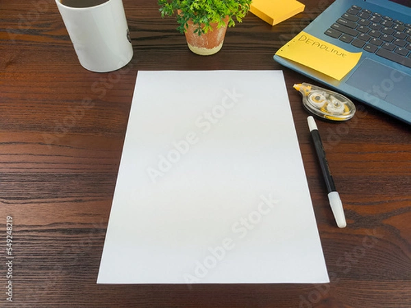 Obraz Flat lay, a mockup of a notebook. A workspace with white notebooks, laptops, office supplies, pencils, and coffee cups in the office background of a wooden desk from top view.