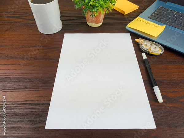 Fototapeta Flat lay, a mockup of a notebook. A workspace with white notebooks, laptops, office supplies, pencils, and coffee cups in the office background of a wooden desk from top view.