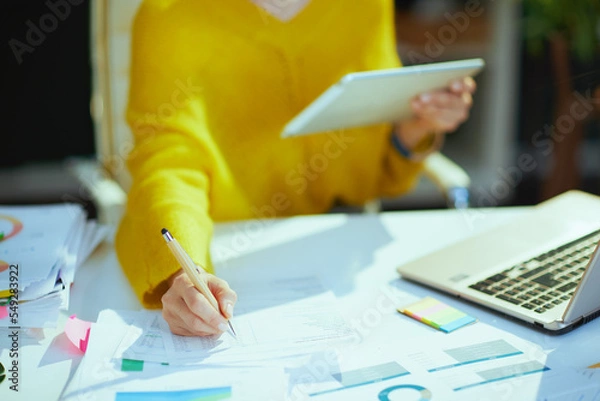 Fototapeta Business owner woman using tablet PC and working with documents