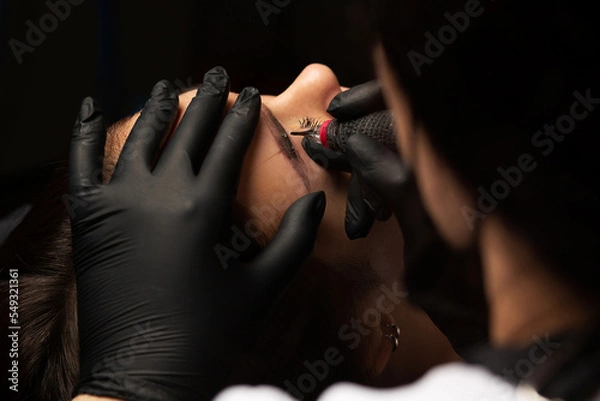 Obraz Beauty master applying permanent makeup
