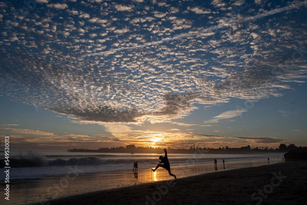 Fototapeta jumping at sunset on the beach