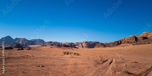 Fototapeta Wadi Rum, Jordan. A beautiful vibrant blue and orange view, Arabian desert, a dystopian martian landscape with unique rock formations and dunes. Backdrop for graphic resource or copy space no people