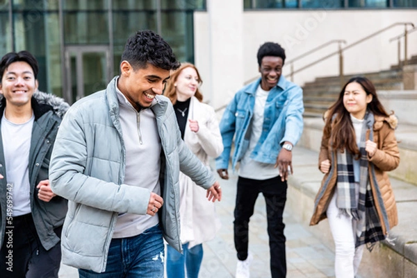 Fototapeta Multiracial friends running and enjoying time together at city or university
