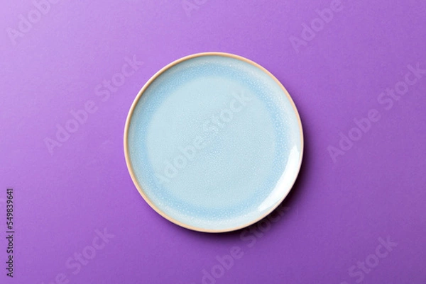 Fototapeta Top view of isolated of colored background empty round blue plate for food. Empty dish with space for your design