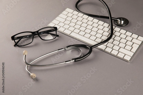 Fototapeta Stethoscope, glasses and keyboard on desktop
