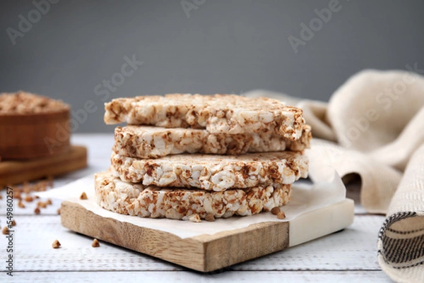 Fototapeta Stack of crunchy buckwheat cakes on white wooden table
