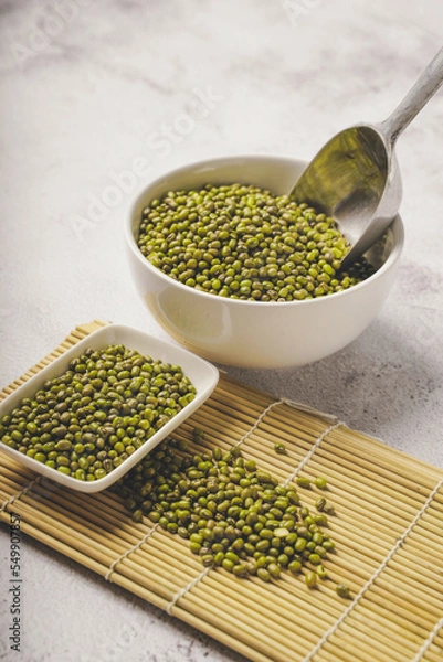 Fototapeta fresh mung beans in ceramic dishes against a white stone background, coppy space.