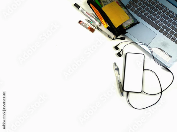Fototapeta Flat lay,background mockup. the workspace in the background of the desk is white from the top view. layout space with mobile phones, laptop, books, pencils, stationery on a white desk background.