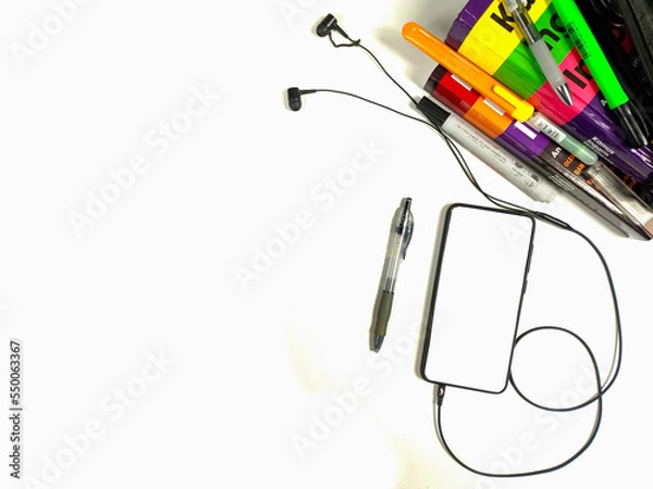 Fototapeta Flat lay,background mockup. the workspace in the background of the desk is white from the top view. layout space with mobile phones, books, pencils, stationery on a white desk background.