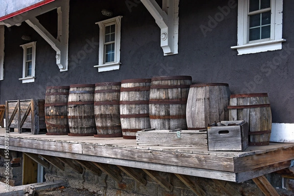 Fototapeta A row of old wooden barrels on a loading dock