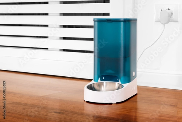 Fototapeta Close-up of an automatic dry cat food dispenser. Pet feeding concept remotely with wifi and online scheduling. Elegant home dispenser. Distance feeding for domestic cats.