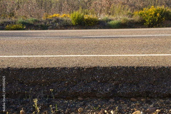 Fototapeta Cross sectional view of the asphalt  base layer  or firm with gravel and asphalt of a road at ground level  