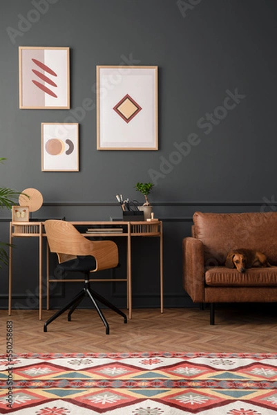 Fototapeta Cozy living room interior with mock up poster frame, brown sofa, wooden desk, modern armchair, patterned rug, books, dog, grey wall, herringbone floor, and personal accessories. Home decor. Template.