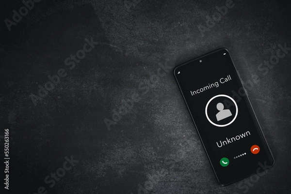 Fototapeta closeup smart phone screen with incoming call by unknown on rough grey background