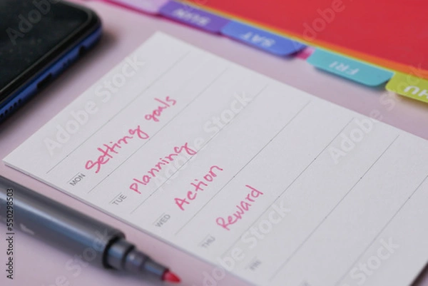 Fototapeta tick mark on planning goals on notepad 