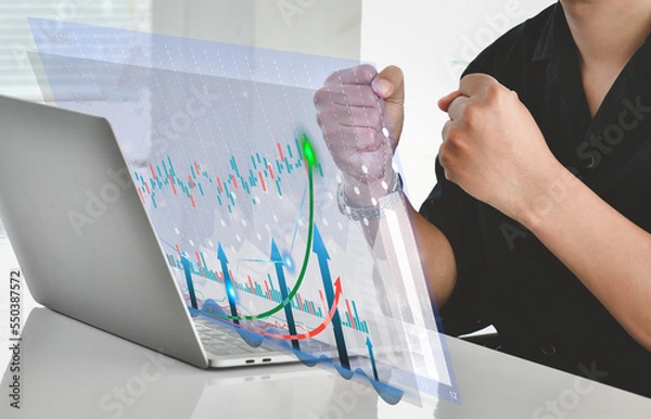 Fototapeta Business man celebration and happy.Investment concept and business finance technology. Stock Market Investments Funds and Digital Assets,analyzing trading graph financial data.