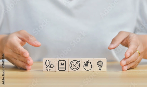 Fototapeta business strategy, Action plan, Goal and target, hand stack woods block step on table with icon about business strategy and Action plan. business development concept. copy space