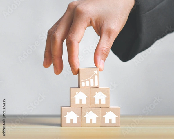 Fototapeta Concept of real estate sales growth with icon on wooden cube stack,loan investment residential building house, real estate, property, mortgage.Arrow graph with house graph