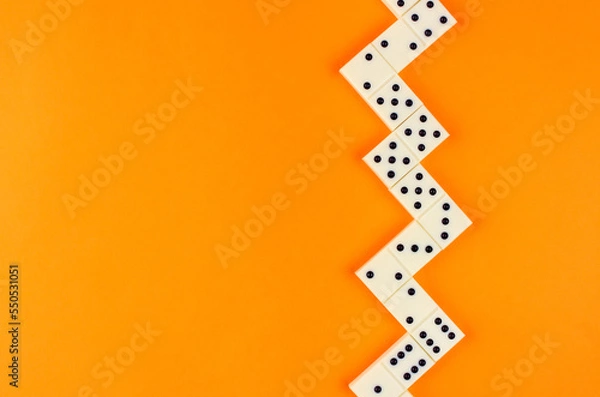 Fototapeta White domino stacked herringbone on an orange background
