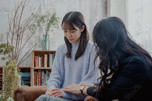 Obraz 若い女性に寄り添って共感的に話を聞くミドルエイジの女性