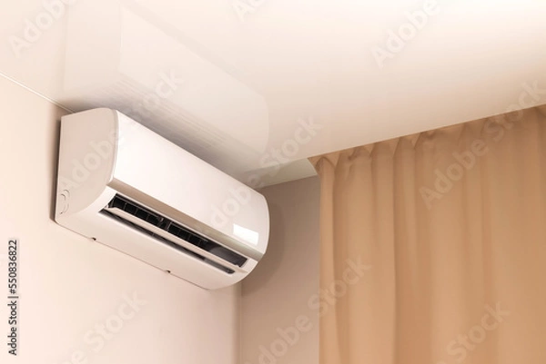 Fototapeta White air conditioner under stretch ceiling in modern room with beige curtains