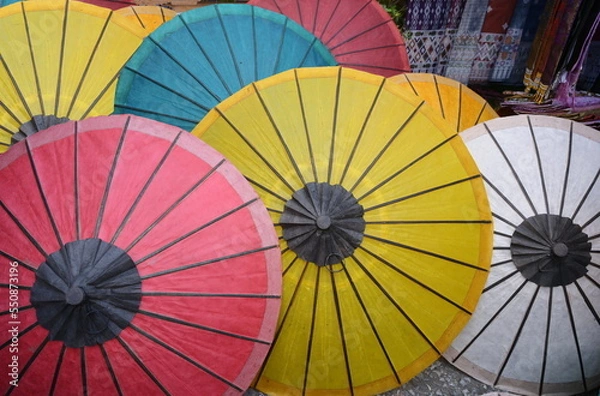 Obraz Colorful mulberry paper umbrellas are sold at souvenir shops. White, yellow, red, orange, blue handmade umbrellas made from dyed mulberry paper are used to protect the sun and decorate the place.
