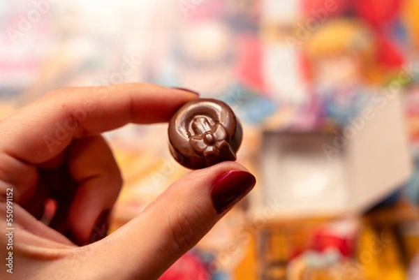 Obraz Christmas advent calendar chocolate for kids, girl holding a candle wreath choco dessert, colorful yellow bokeh bg