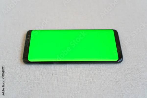 Obraz Mobile phone on table horizontally with blank screen