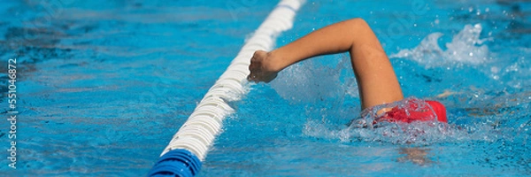 Fototapeta Swimmer child athlete swimming in pool lanes doing a crawl lap. Sport activities for children