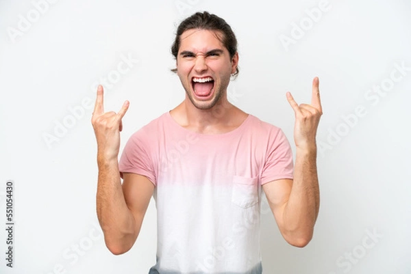 Fototapeta Caucasian handsome man isolated on white background making horn gesture
